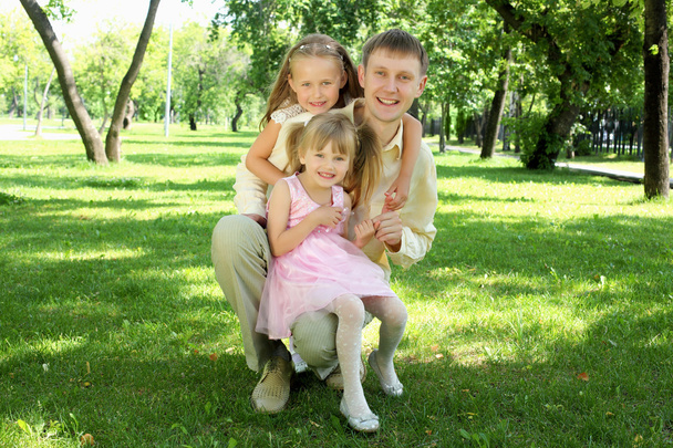 Padre con dos hijas afuera
 - Foto, Imagen