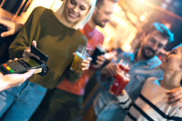 Różnorodni przyjaciele w barze płacą urządzeniem komórkowym - Zdjęcie, obraz