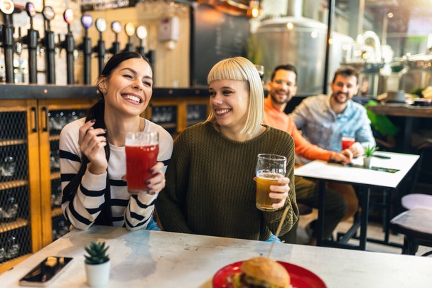 Souriant jeunes amis boire de la bière artisanale dans le pub - Photo, image