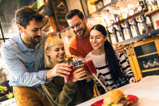 Sorrindo jovens amigos bebendo cerveja artesanal no pub - Foto, Imagem