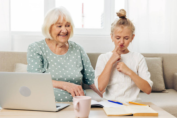 Переймаючись білим усміхненим простором дитина в приміщенні люди відео щасливе сімейне селфі онука диван освіта футболка фотографія ноутбук бабуся перемикається дві копії зв'язку - Фото, зображення
