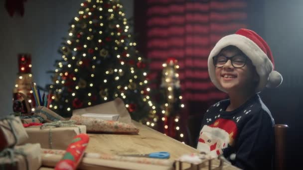 デスクで笑顔でプレゼントを準備する子供 . - 映像、動画