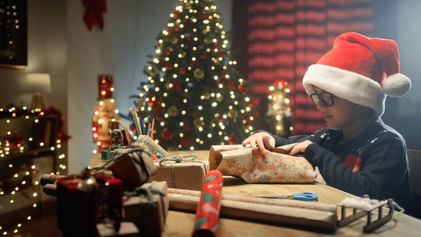 Kid preparing Christmas gifts for his family on table. - Photo, Image
