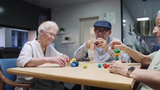 Video de tres personas mayores en un hogar de ancianos compartiendo juegos de habilidades - Imágenes, Vídeo