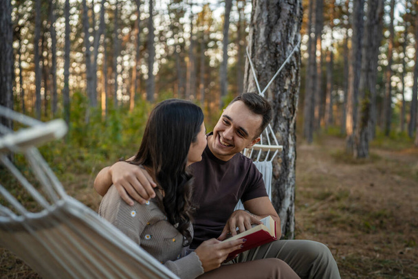 Hombre y mujer joven pareja adulta en la naturaleza celebrar y leer el libro en el amor - Foto, imagen