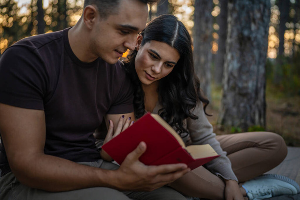 Чоловік і жінка молода доросла пара в природі тримають і читають книгу в любові - Фото, зображення