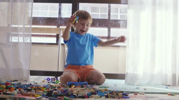 Mały chłopiec siedzący na podłodze bawiący się zabawkami. - Materiał filmowy, wideo