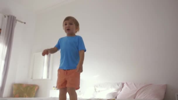 Un jeune garçon debout sur un lit - Séquence, vidéo