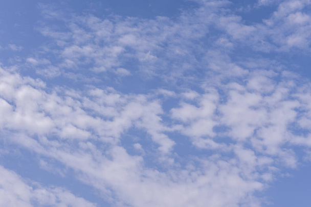 Un cielo azul con nubes esponjosas en un día cálido - Foto, imagen