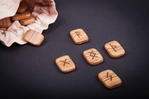 runes for predictions burned on wooden plates on a black background - Photo, Image