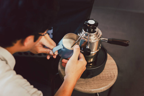 Hombre calentando leche En jarra de metal con máquina de café de vapor en el camping al aire libre - Foto, imagen