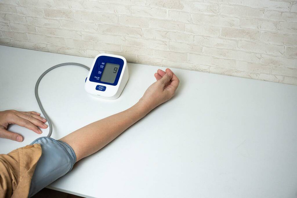 自宅で血圧を測定する若い女性. 自己血圧と心拍数 - 写真・画像
