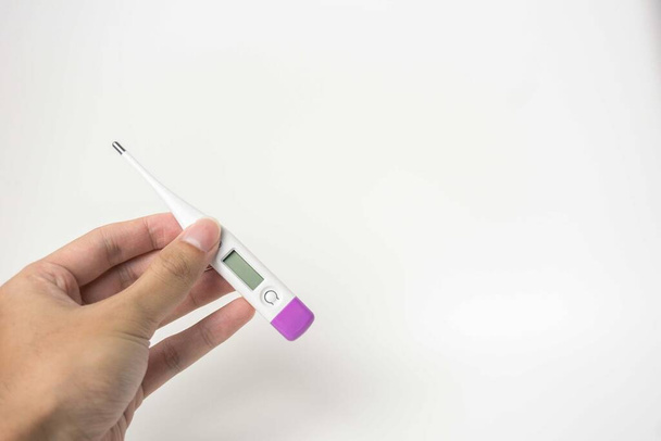 Dijital termometreyi tutan kadın eller. Kız sıcaklığı ölçer. Ateş ve sağlık hizmeti kavramı - Fotoğraf, Görsel