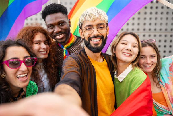 Onnelliset ystävät ottavat selfien valokuvan kaupungissa - Nuoret monipuoliset vaihtoehtoiset ihmiset, joilla on hauskaa LGBT-sateenkaaren lippujen kanssa - Valokuva, kuva