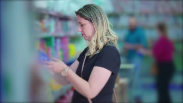Blonde Frau kauft im Supermarkt ein, um Produkte zu kaufen - Filmmaterial, Video