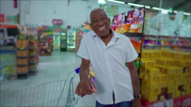 portré afro-amerikai férfi vezető munkás bevásárlókocsi mosolyog, és nézi a kamera a szupermarketben - Felvétel, videó