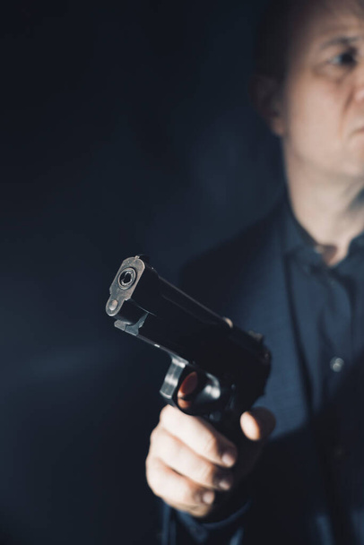 mercenario sicario espía assasin detective con pistola retrato estudio disparo foto. - Foto, imagen