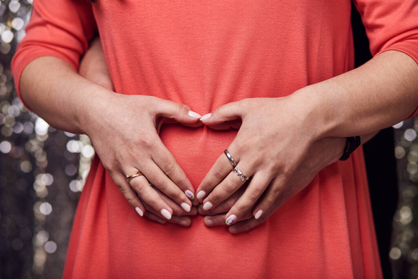 Крупный план беременной женщины, держащей живот. Мать ждет новорожденного ребенка - Фото, изображение