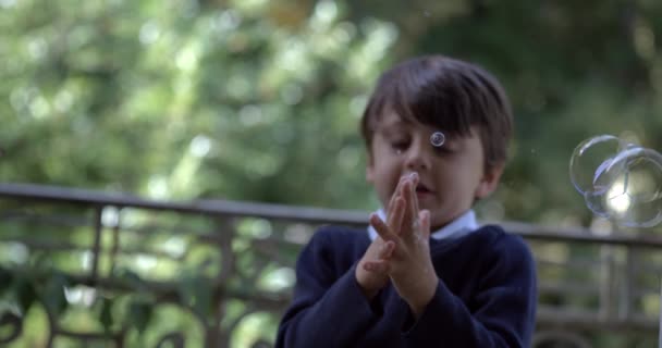 Egy kisfiú buborékszappan, kezekkel, szuper lassított felvételekkel, 800 fps sebességgel az erkélyen. - Felvétel, videó