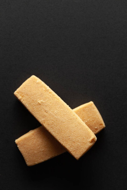 Dos dulces y sabrosas galletas de mantequilla de coco, sobre un fondo negro. Vista de arriba hacia abajo. Comida plana lay. - Foto, imagen
