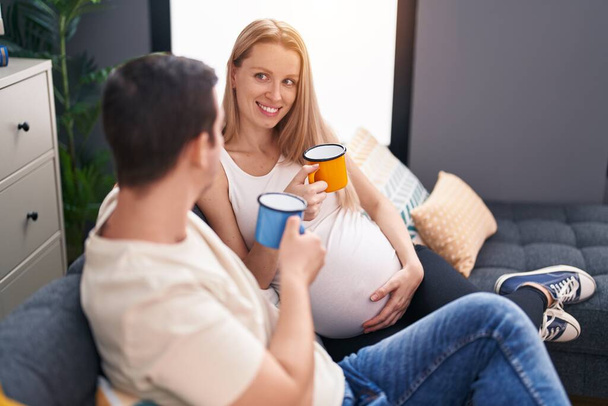 Hombre y mujer pareja esperando bebé bebiendo café en casa - Foto, imagen
