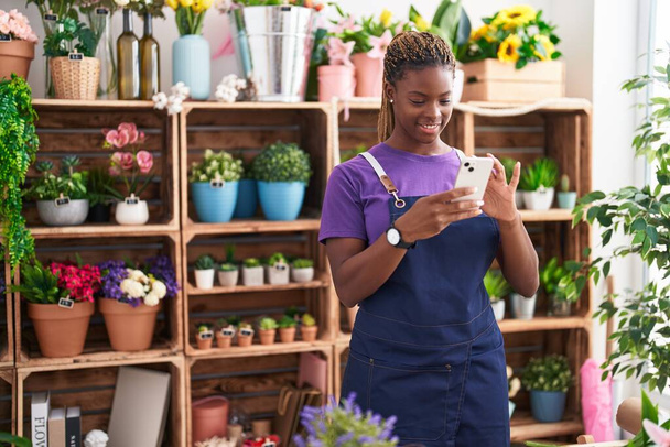 African american woman florist smiling confident using smartphone at florist - Photo, Image