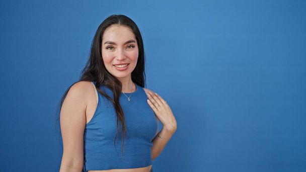 Young beautiful hispanic woman smiling confident standing over isolated blue background - Фото, изображение
