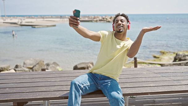Африканский американец записывает видео на смартфон, танцующий на берегу моря - Фото, изображение