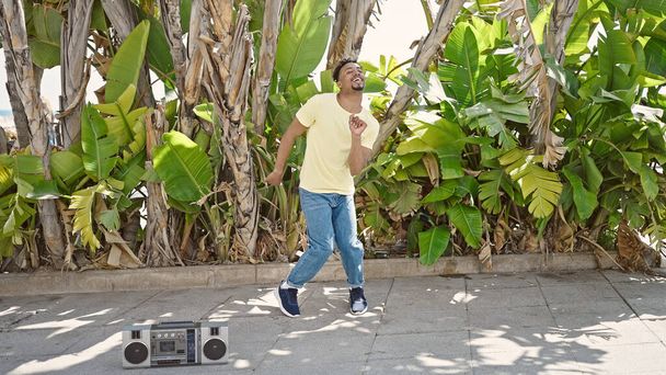 Uomo afroamericano sorridente sicuro di sé che balla al parco - Foto, immagini