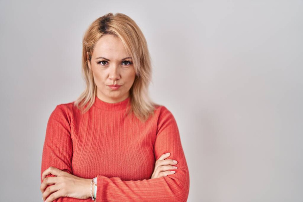 Blonde woman standing over isolated background skeptic and nervous, disapproving expression on face with crossed arms. negative person.  - Photo, Image