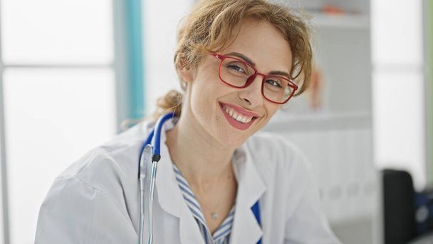 Junge Ärztin mit Brille lächelt in der Klinik - Foto, Bild