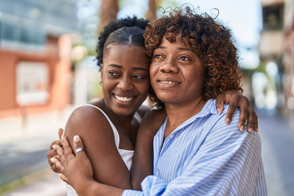 Африканские американские женщины мать и дочь обнимаются на улице - Фото, изображение