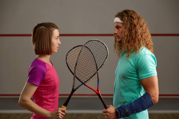 Mies ja nainen squash pelaaja vastakkainasettelu tuomioistuimen käsite. Mies ja nainen ammattilaisurheilussa tasa-arvon käsite - Valokuva, kuva