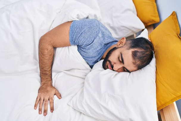 Genç İspanyol adam yatakta uzanıp yatak odasında uyuyor. - Fotoğraf, Görsel