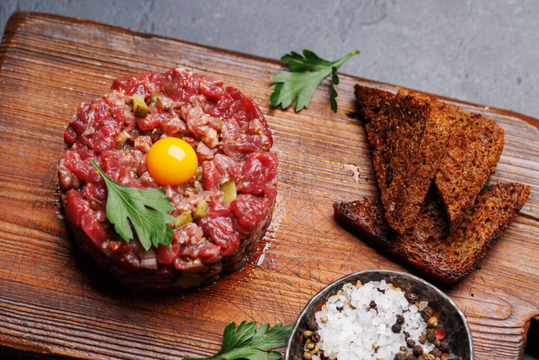 Savory beef tartare with pickled gherkins and brown bread toasts - Photo, Image