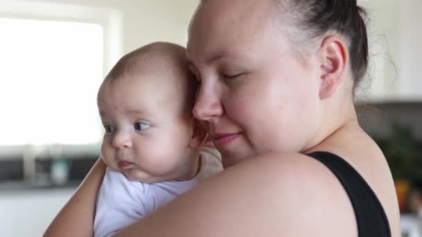 Mama en baby knuffelen samen thuis, ouderlijk liefdesconcept - Video
