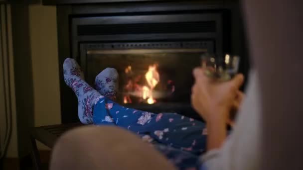 暖炉の近くでホットドリンクを飲んでいる女性 - 映像、動画