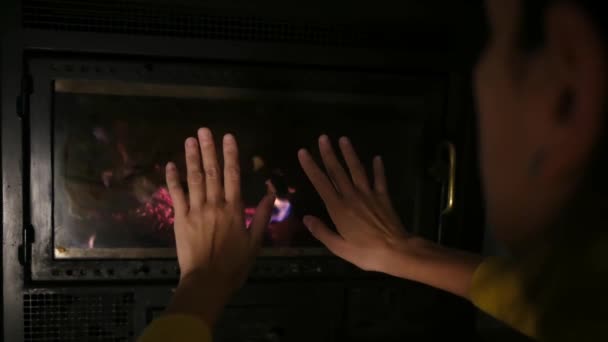 vrouw verwarmende handen in de buurt open haard - Video