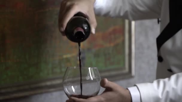 samec sommelier nalévá víno ve vinném skle - Záběry, video