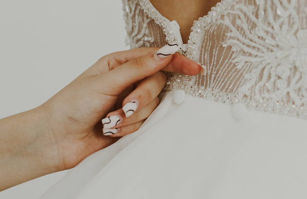 Jovem caucasiano menina zipping vestido de noiva na parte de trás da noiva, close-up vista do lado. - Foto, Imagem