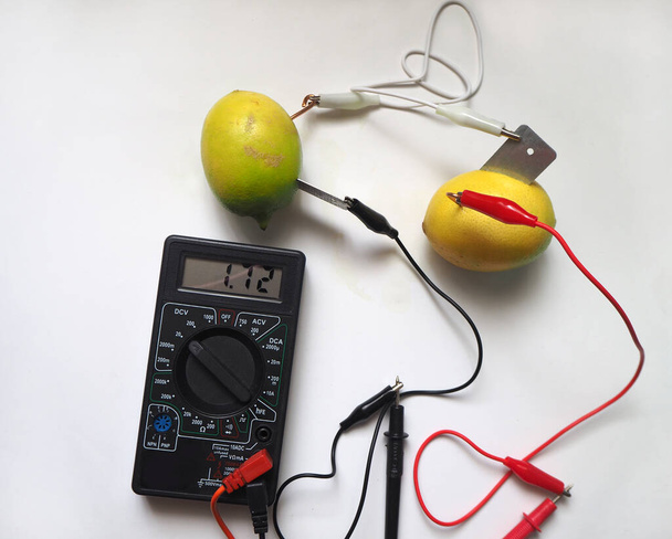 Measuring voltage with voltmeter from serial connected electrical sources. Lemon battery. Bio battery. - Photo, Image