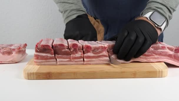 Řezník krájí mršinu masa. Detailní záběr nože, jak krájí kus syrového masa. Detailní záběr na syrové maso. - Záběry, video