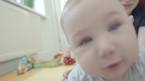 Een baby die met de camera wil spelen. Portret - Video