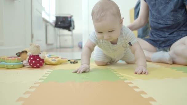 Ein kleines Baby krabbelt auf dem Teppich. Mittelschuss - Filmmaterial, Video