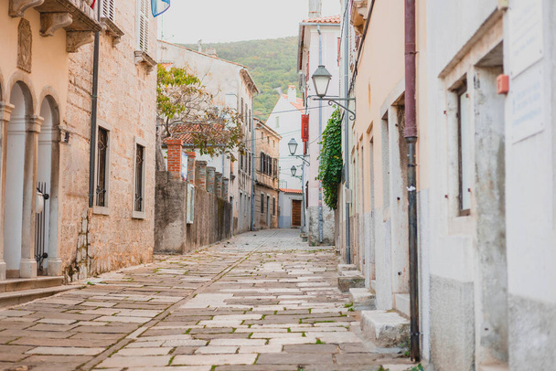 Cres keskeny utcái, macskaköves utak, régi házak és szűk sikátorok egy tipikus horvát tengerparti vagy szigeti városban. - Fotó, kép