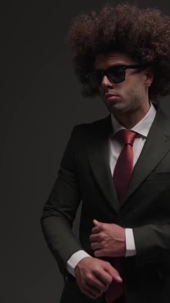 gelukkig elegant zakenman in zwart pak bewegen, plezier hebben en dansen, knikken en goed te keuren in de voorkant van grijze achtergrond - Video