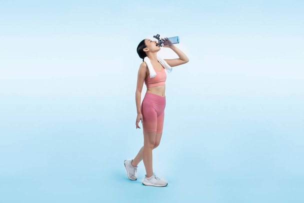 Donna asiatica atletica e sportiva che riposa e beve acqua dopo un intenso allenamento cardio. Esercizio sano e in forma stile di vita di cura del corpo inseguimento in studio girato sfondo isolato. Vigoroso - Foto, immagini