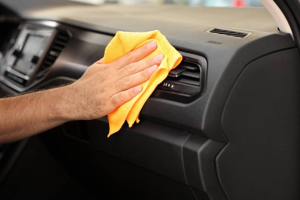 Man cleaning car interior with rag, closeup - Foto, afbeelding