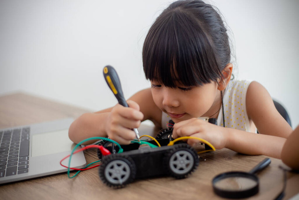nventive kids learn at home by coding robot cars and electronic board cables in STEM. constructing robot cars at home - Photo, Image