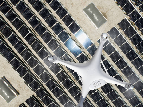 Luftaufnahme einer Drohne, die über einem mit Solarzellen bedeckten Dach einer Industriehalle fliegt. - Foto, Bild
